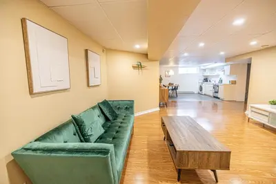 a living room with a green couch and a wooden table at Spacious 2BDRs Apt,ALL NEW! Close to DT , 1 parking in Brossard