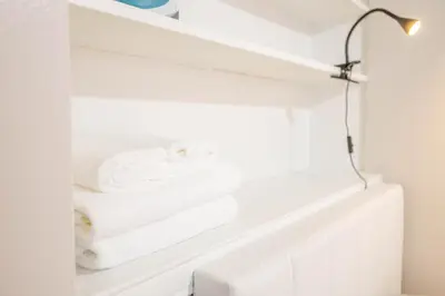 a closet with white towels on a shelf at Studio in heart of DT,walk to 2 metros,Concordia in Montréal