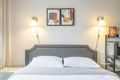 a bedroom with a bed with two lamps on the wall at Studio in heart of DT,walk to 2 metros,Concordia in Montréal