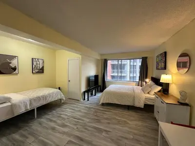 a hotel room with two beds and a window at studio in heart of DT, 2 metros, Concordia in Montréal
