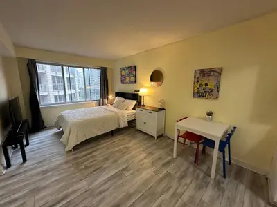 a bedroom with a bed and a table and a desk at studio in heart of DT, 2 metros, Concordia in Montréal