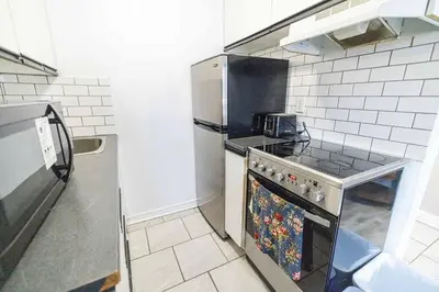 a kitchen with a stove and a refrigerator at studio in heart of DT, 2 metros, Concordia in Montréal