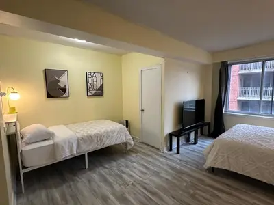 a hotel room with two beds and a window at studio in heart of DT, 2 metros, Concordia in Montréal