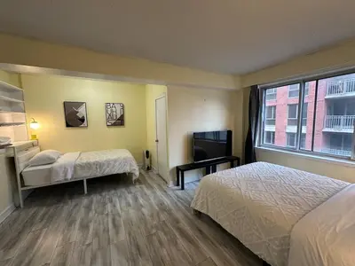 a hotel room with two beds and a television at studio in heart of DT, 2 metros, Concordia in Montréal