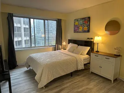 a bedroom with a bed and a large window at studio in heart of DT, 2 metros, Concordia in Montréal