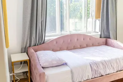 a pink bed in a room with a window at 1 BDR at heart of DT, walk to 2 metros, Concordia in Montréal