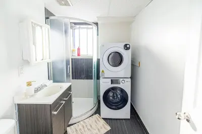 a bathroom with a washing machine next to a sink at 1 BDR at heart of DT, walk to 2 metros, Concordia in Montréal