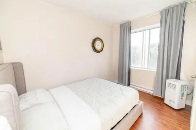a white bed in a room with a window at 1 BDR at heart of DT, walk to 2 metros, Concordia in Montréal