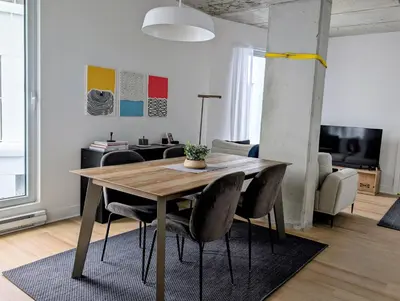 a dining room table and chairs in a living room at Old Montreal Suite with Rooftop Pool & Terrace in Montréal