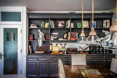 a dining room with a table and a shelf with books at Villa Nao in Roxton Falls