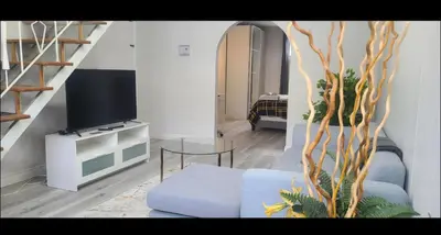 a living room with a blue couch and a tv at Private rooms in shared appartment in Montréal