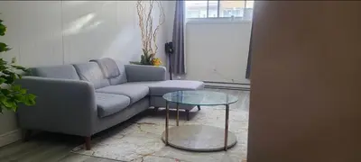 a living room with a couch and a glass table at Private rooms in shared appartment in Montréal
