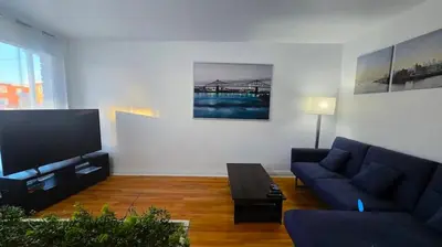 a living room with a couch and a tv at Private rooms in shared appartment in Montréal