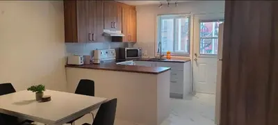 a kitchen with a table and a counter top with a table and a tableablish at Private rooms in shared appartment in Montréal