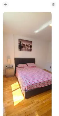 a bedroom with a bed with a striped comforter at Private rooms in shared appartment in Montréal