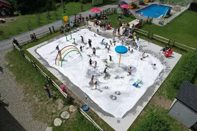 a group of people playing in a water park at Camping de la Rivière Nicolet in Wotton