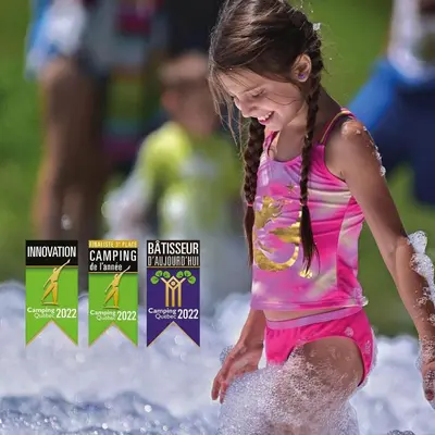 a young girl is running in the water at Camping de la Rivière Nicolet in Wotton