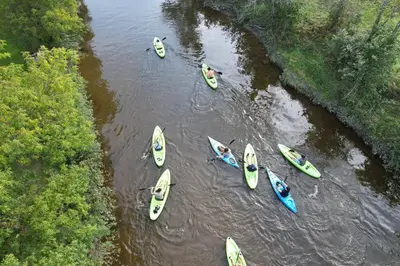a group of kayaks lined up in the water at Camping de la Rivière Nicolet in Wotton