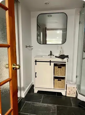 a bathroom with a white sink and a mirror at Studio moderne et tranquille in Montréal
