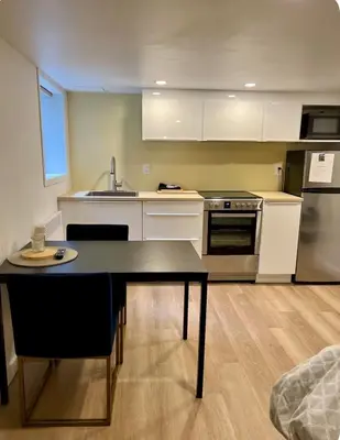 a kitchen with a table and a sink and a stove at Studio moderne et tranquille in Montréal