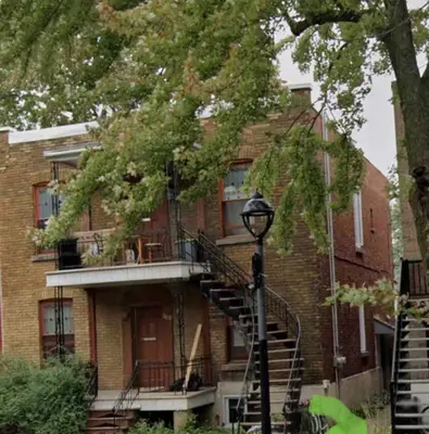 a brick building with a staircase in front of it at Studio moderne et tranquille in Montréal