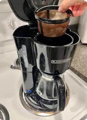 a person is making coffee in a coffee maker at Studio moderne et tranquille in Montréal