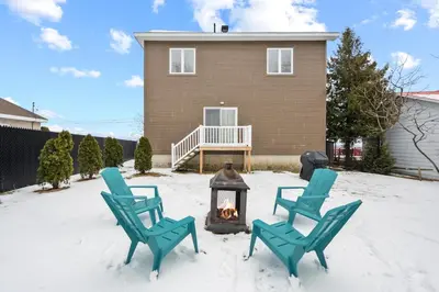 two chairs and a fireplace in front of a house at A Getaway on Lake Champlain in Venise-en-Québec
