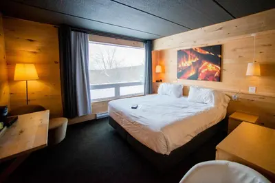 a bedroom with a large bed and a large window at Hotel de l'Horizon in Sutton