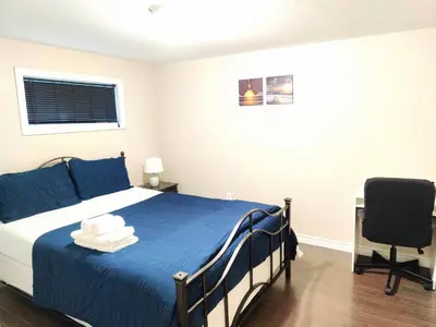 a bedroom with a bed and a desk and a chair at Family-Friendly Spacious 2BR Cozy Basement Suite - Near Attractions - Sleepsn5 in Longueuil