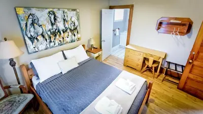 a bedroom with a bed and a piano at Auberge Ayer's Cliff in Ayer's Cliff