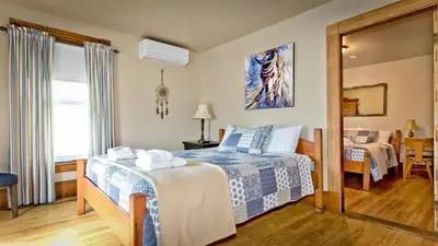 a hotel room with a bed and a mirror at Auberge Ayer's Cliff in Ayer's Cliff