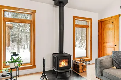 a living room with a wood stove in it at Chalet Eastman in Eastman