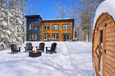 a house in the snow with chairs and a fireplace at Chalet Eastman in Eastman