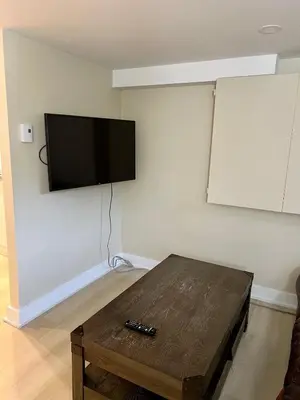a room with a table and a flat screen tv on a wall at Appartement privé et calme in Montréal