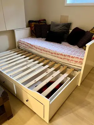 a bed with a wooden frame in a bedroom at Appartement privé et calme in Montréal
