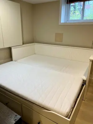 a bed in a room with a white mattress at Appartement privé et calme in Montréal