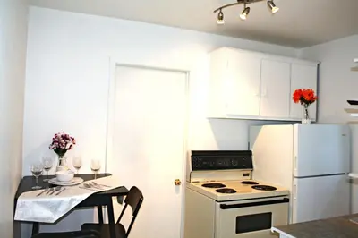 a kitchen with a white refrigerator and a table with chairs at St-Denis II-8 Entire apartment at heart of MTL in Montréal