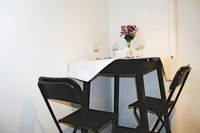 a black table with wine glasses and flowers on it at St-Denis II-8 Entire apartment at heart of MTL in Montréal
