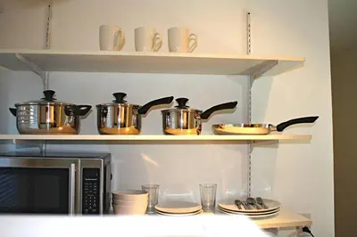 a shelf with pots and pans on top of a microwave at St-Denis II-8 Entire apartment at heart of MTL in Montréal