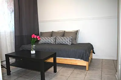 a bedroom with a bed and a table with flowers on it at St-Denis II-8 Entire apartment at heart of MTL in Montréal