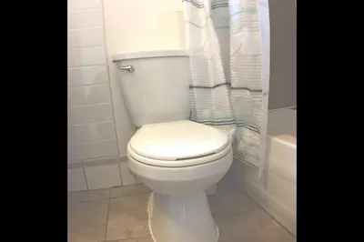 a white toilet in a bathroom with a shower at St-Denis II-8 Entire apartment at heart of MTL in Montréal