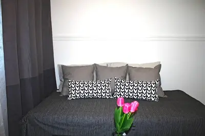 a bed with black and white pillows and pink flowers at St-Denis II-8 Entire apartment at heart of MTL in Montréal