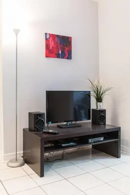 a entertainment center with a flat screen tv and speakers at St-denis II-3 Apt In the heart of Montreal in Montréal