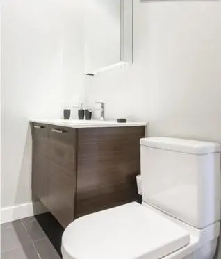 a bathroom with a white toilet and a sink at Le Mont-Royal Lounge by HomeInMontreal in Montréal