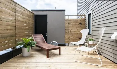 a patio with two chairs and a bench on a deck at Le Mont-Royal Lounge by HomeInMontreal in Montréal