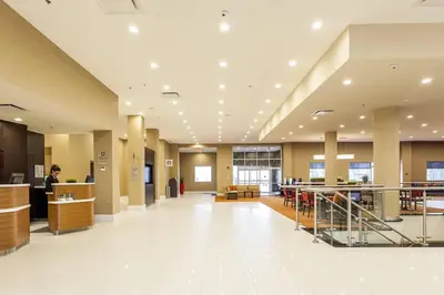 a lobby of a hospital with a woman standing at a counter at Courtyard by Marriott Montreal West Island/Baie D’Urfe in Baie-dʼUrfé