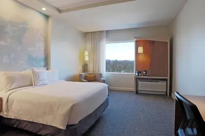 a hotel room with a bed and a window at Courtyard by Marriott Montreal West Island/Baie D’Urfe in Baie-dʼUrfé