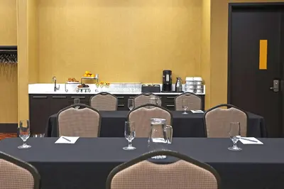 a conference room with tables and chairs with wine glasses at Courtyard by Marriott Montreal West Island/Baie D’Urfe in Baie-dʼUrfé