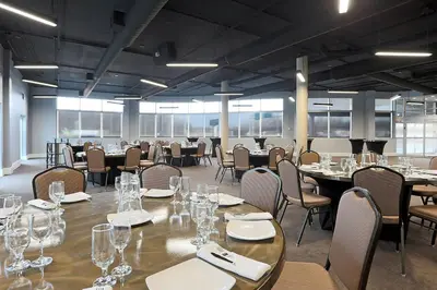 a large room with tables and chairs with wine glasses at Courtyard by Marriott Montreal West Island/Baie D’Urfe in Baie-dʼUrfé