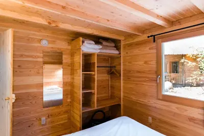a tiny house with wooden walls and a window at Huttopia Sutton in Sutton